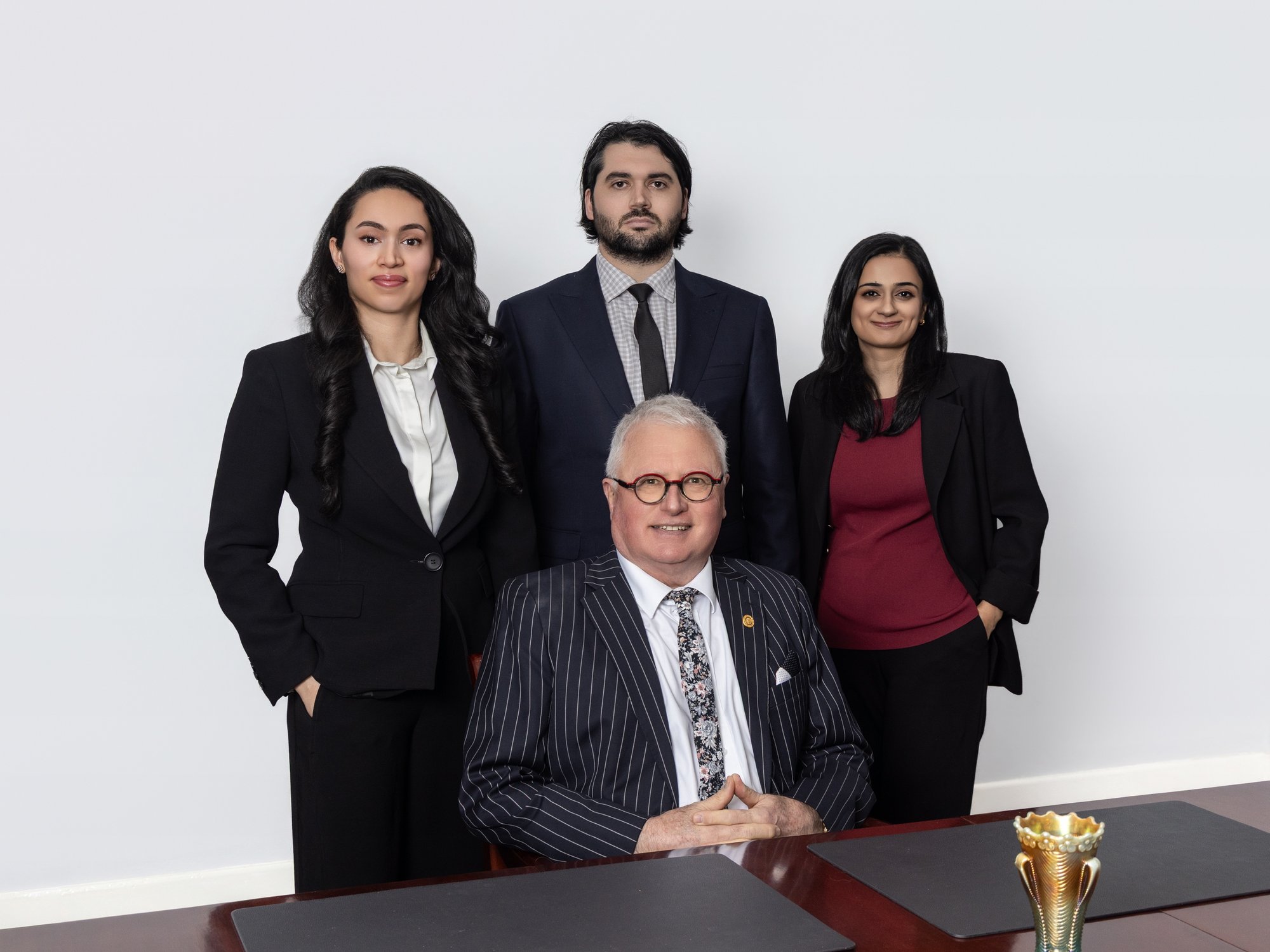 The Steven M Clark Lawyers legal team: Zahra Amin, Jack Clark and Mahima Sobti with Steven M Clark seated